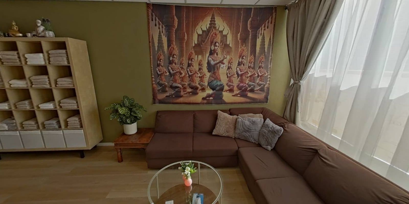 Wachtruimte van Siya Thai Massage met Thais wandkleed en handdoekenkast